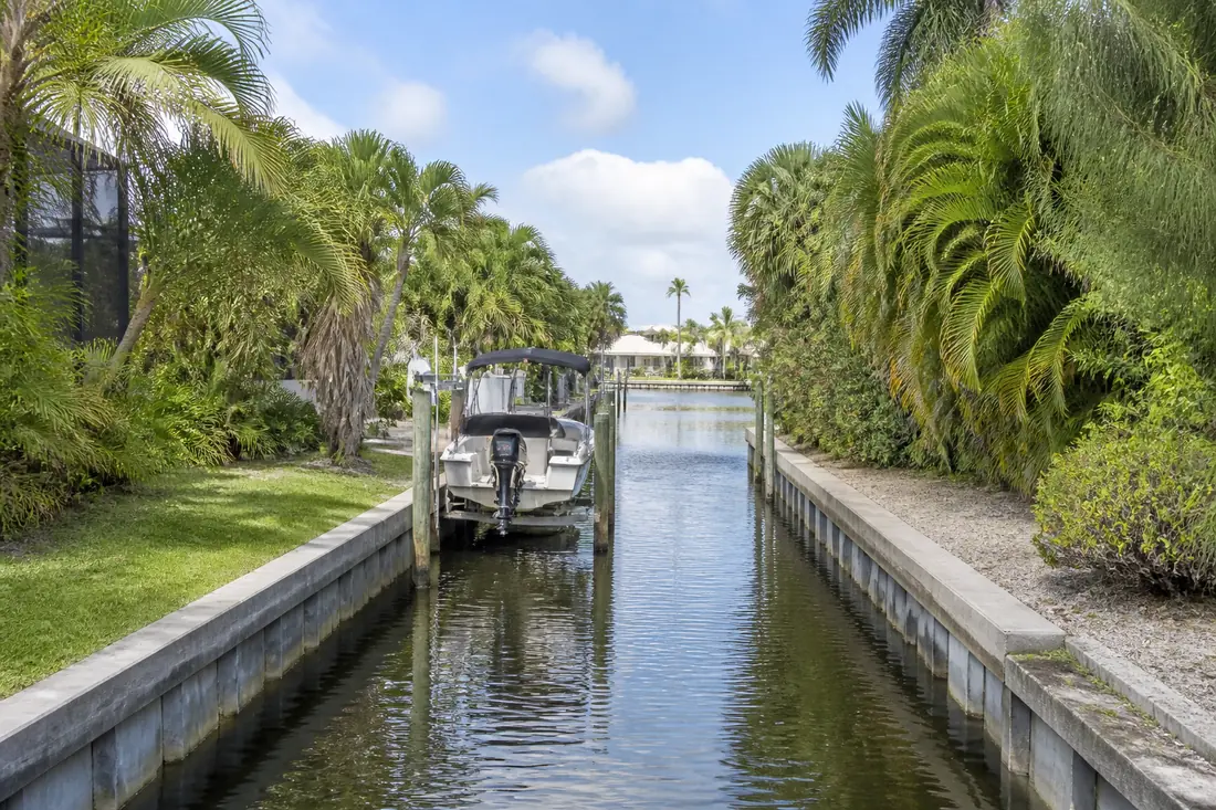 A narrow residential canal with walls close together on both banks