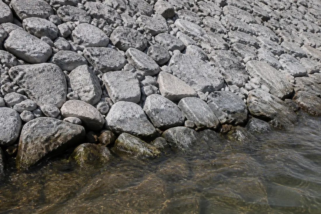 Angular limestone rock graded on a bank slope at the waterline